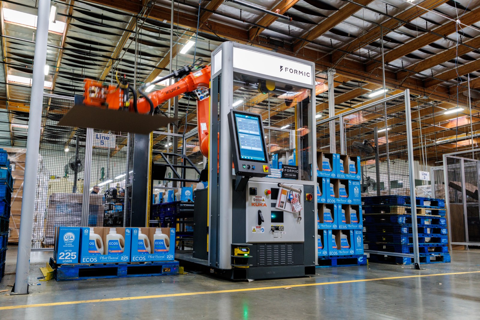 Industrial palletizing cell stacking cases at full line rate.