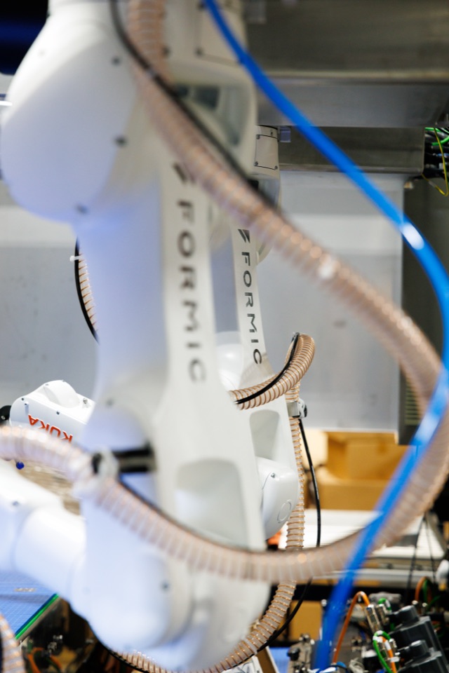 Formic-branded white KUKA arm with Formic Production Intelligence cabling, frontier hardware running under the same Full Service stack