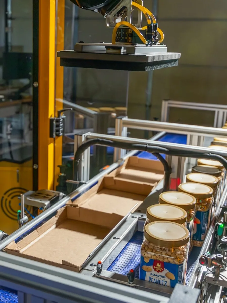 Formic robotic case packer loading jars into open cases on a customer production line