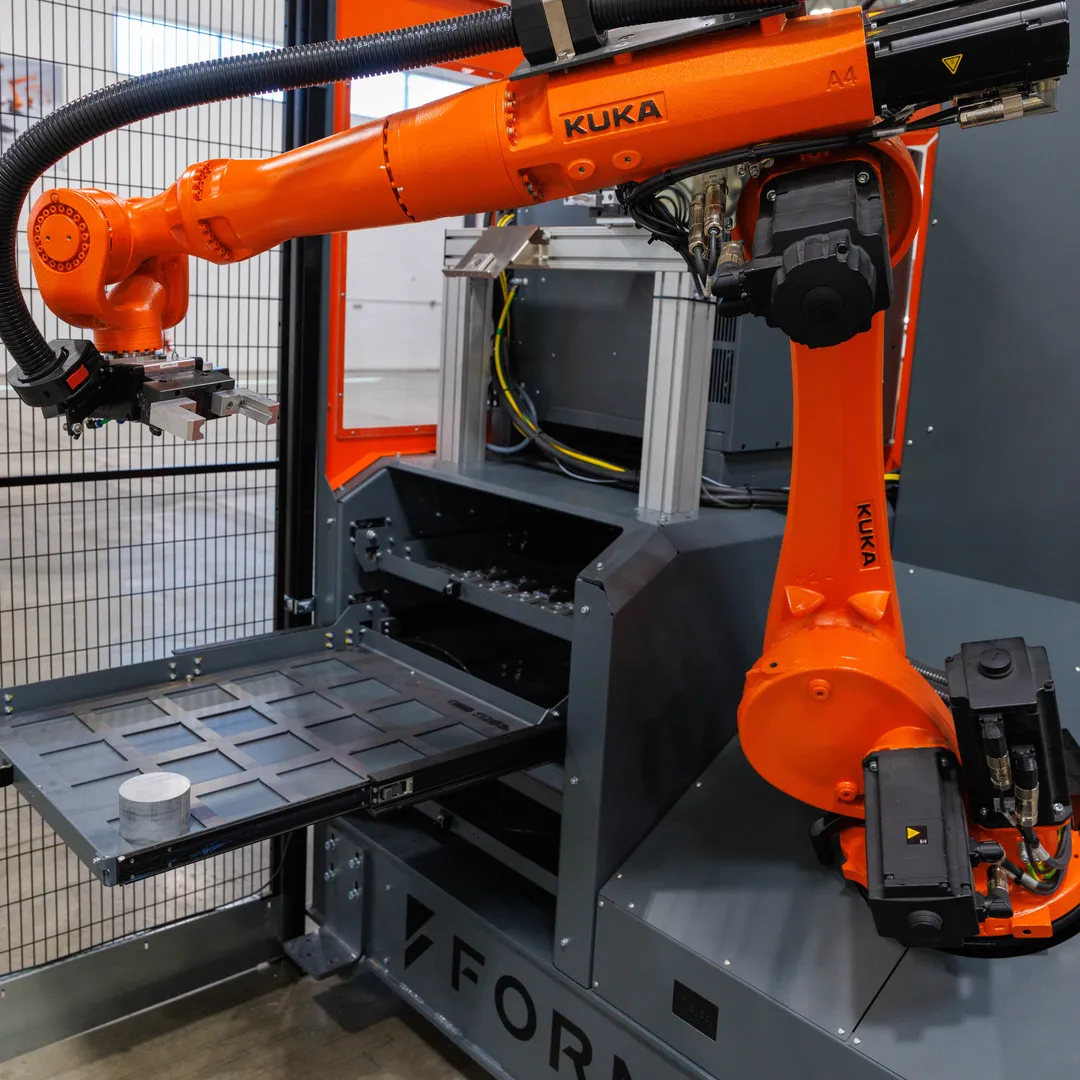 Formic machine-tending cell — a KUKA robot loading a CNC from a slide-out part tray