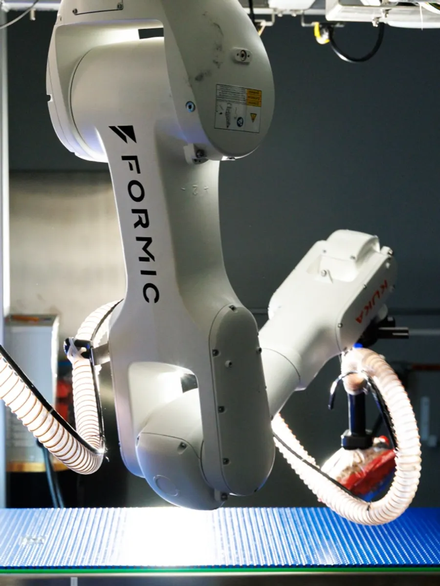 Formic flexible case packer arm picking product over a conveyor