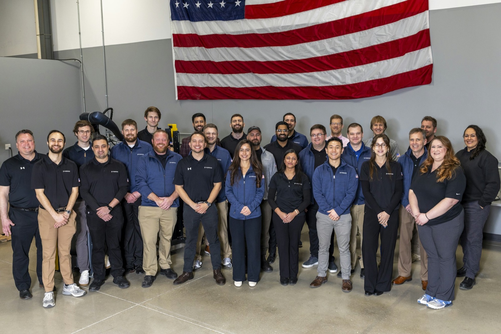 The Formic team posing in front of an American flag, built in Chicago, headquartered in the U.S.