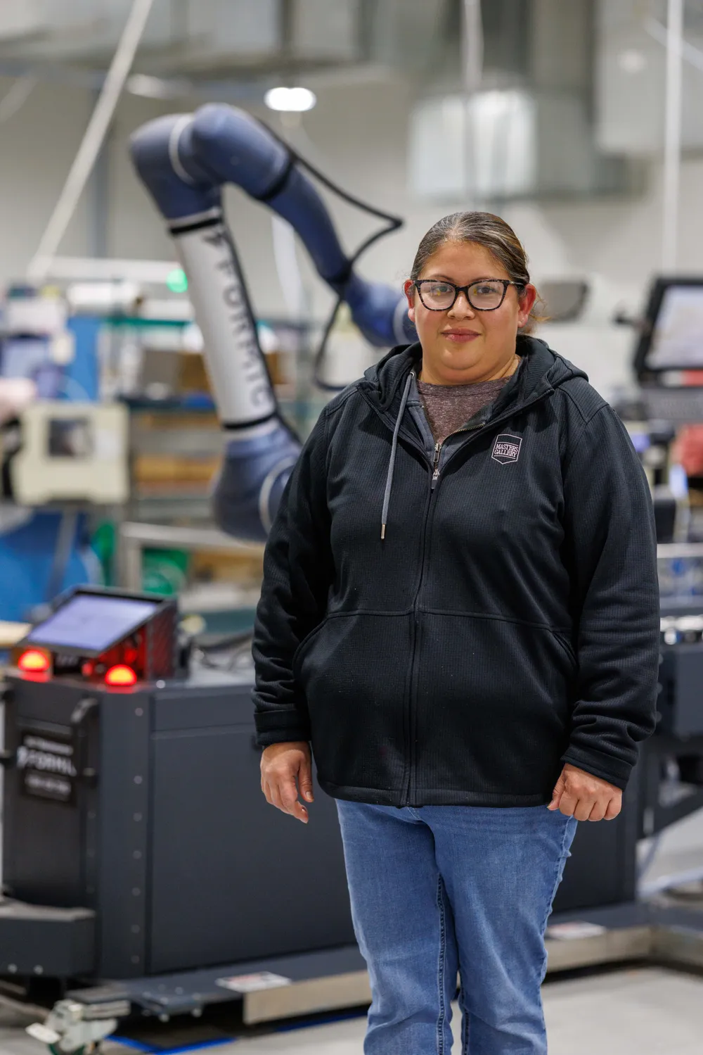 Masters Gallery employee back at higher-value work, with the Formic cobot palletizer running the lifting behind her