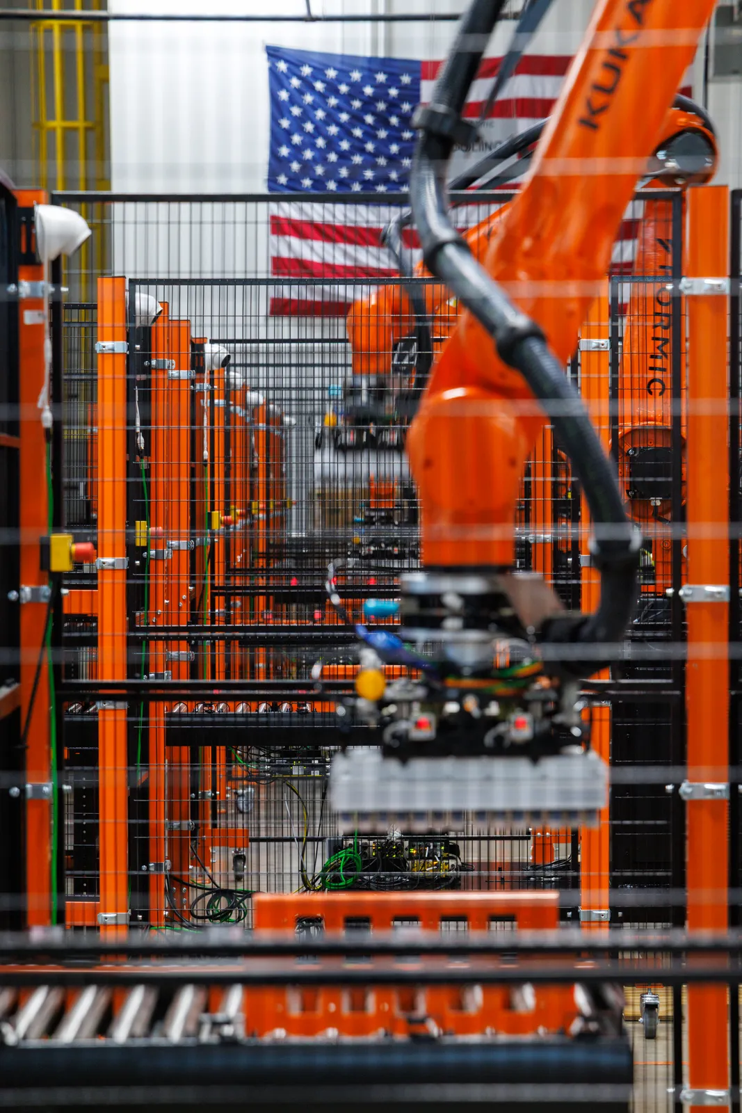 A row of Formic palletizing cells running on the Oakland floor beneath the American flag