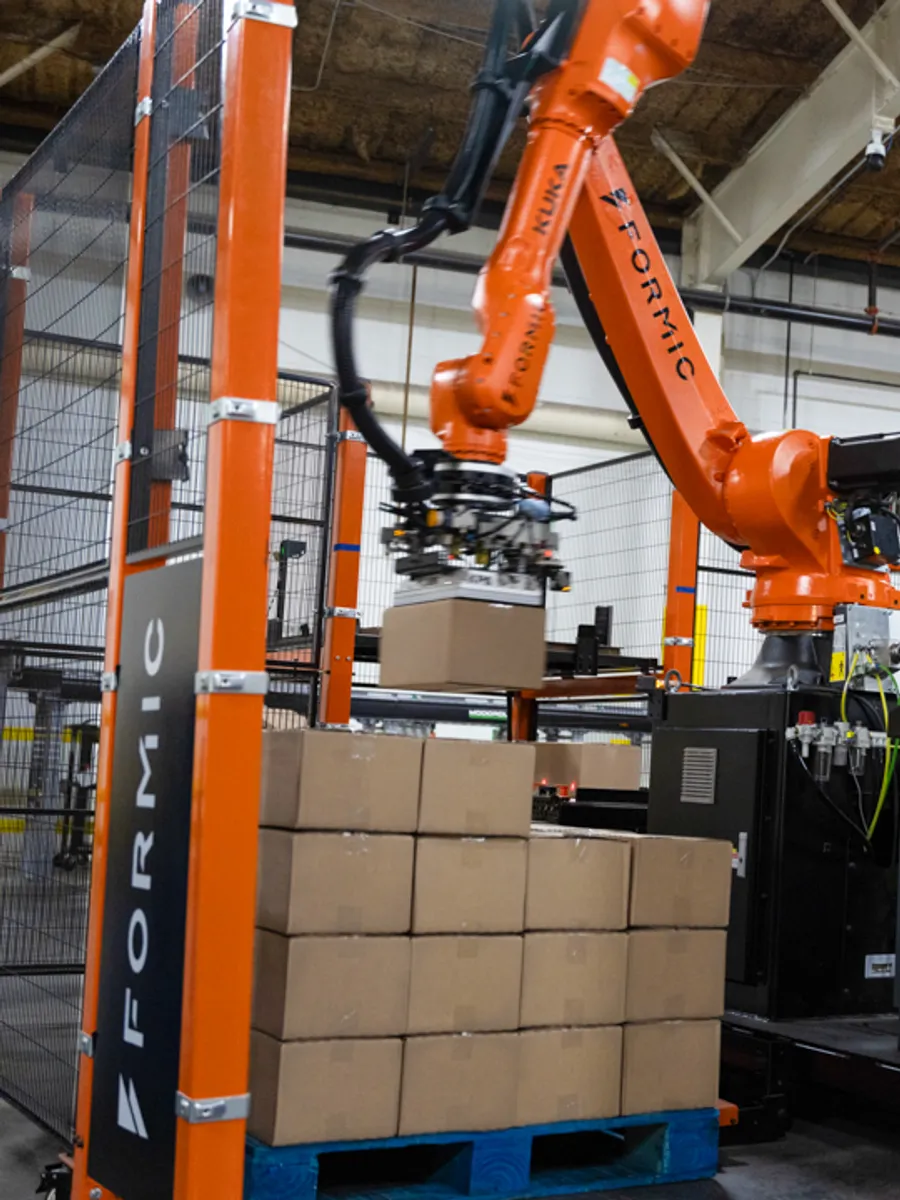 Formic palletizing cell finishing a full pallet of cases on a customer line